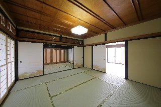 ４つの和室のうち、二間は洋室にしてリビングに（右）　建具だけで仕切られていたところは、半分を壁にしてじゅらくを塗って仕上げています。　奥に見える扉の向こうが玄関ホール。